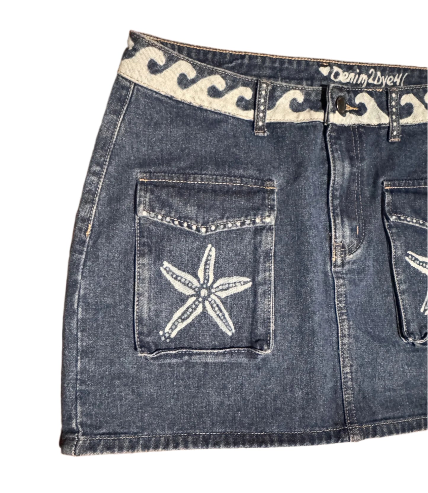 "Hand-bleached denim mini skirt with cargo pockets, starfish and wave design – size 10 one-of-a-kind"
