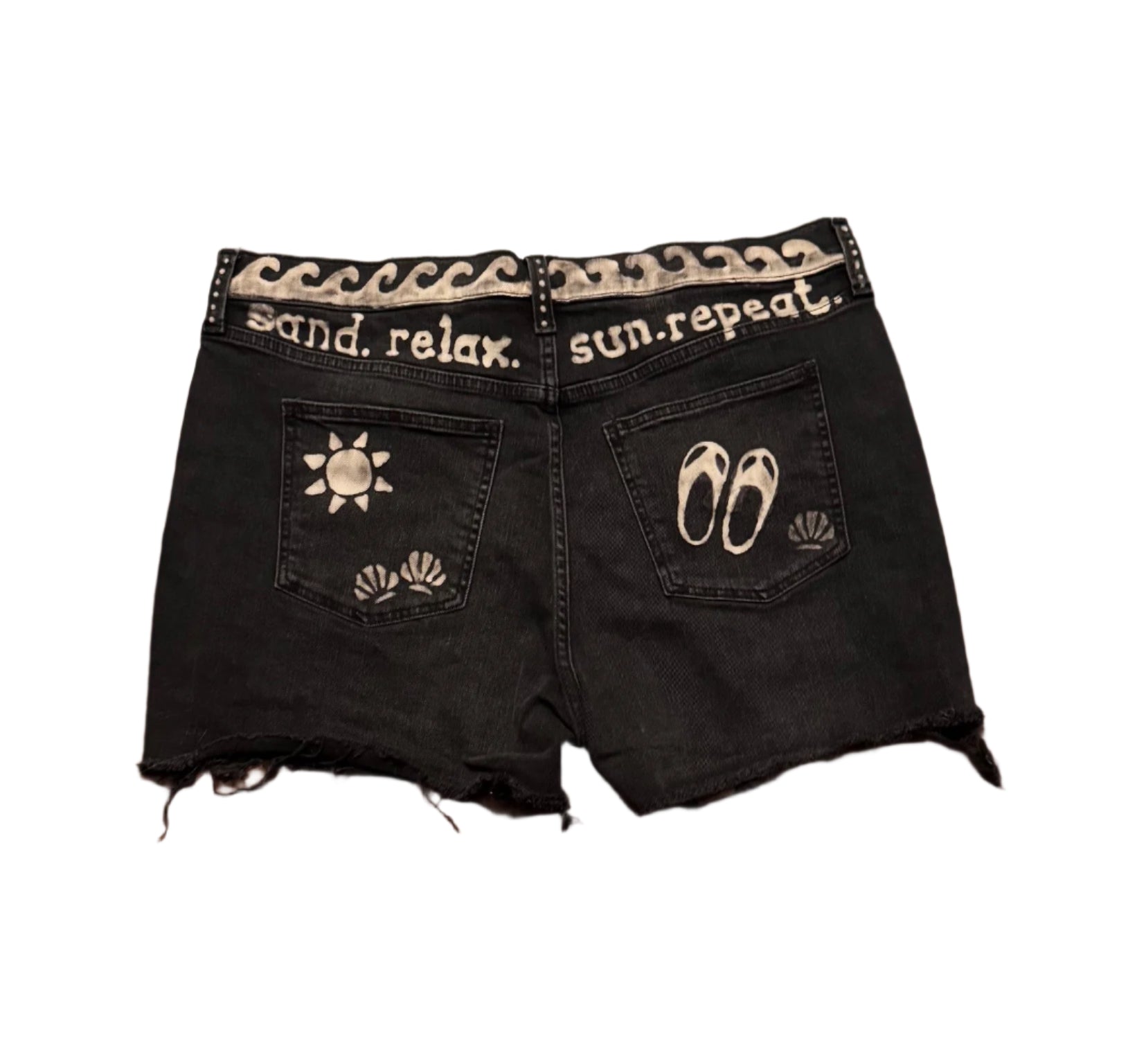 Black GAP hand-bleached 4-inch denim shorts with wave waist, mini shell at hemline, back waist wording “Sand, Relax, Sun and Repeat,” sun, shells and sandals on pockets