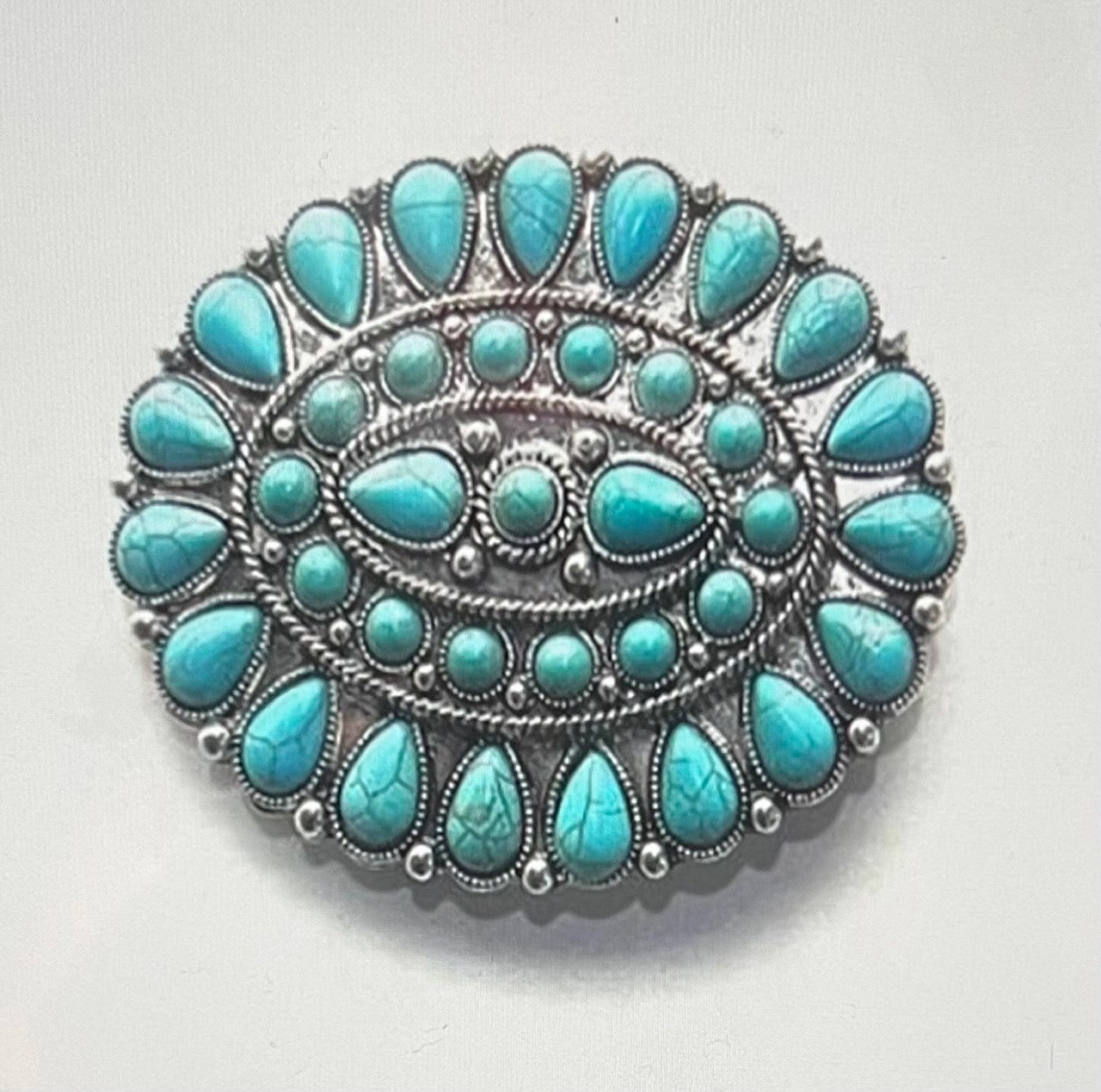Oval belt buckle with turquoise concho design