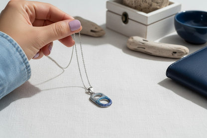 woman holding coastal wave necklace silver
