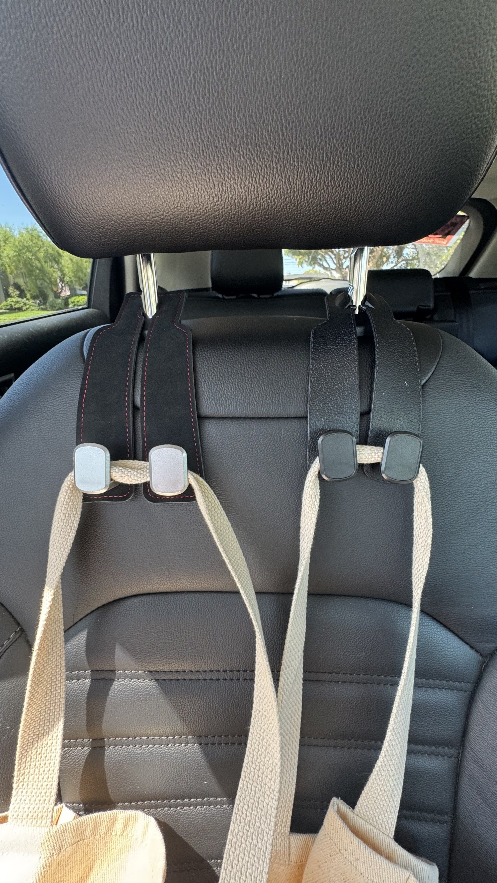 The Purse Perch™ organizing groceries and shopping bags behind a vehicle seat.